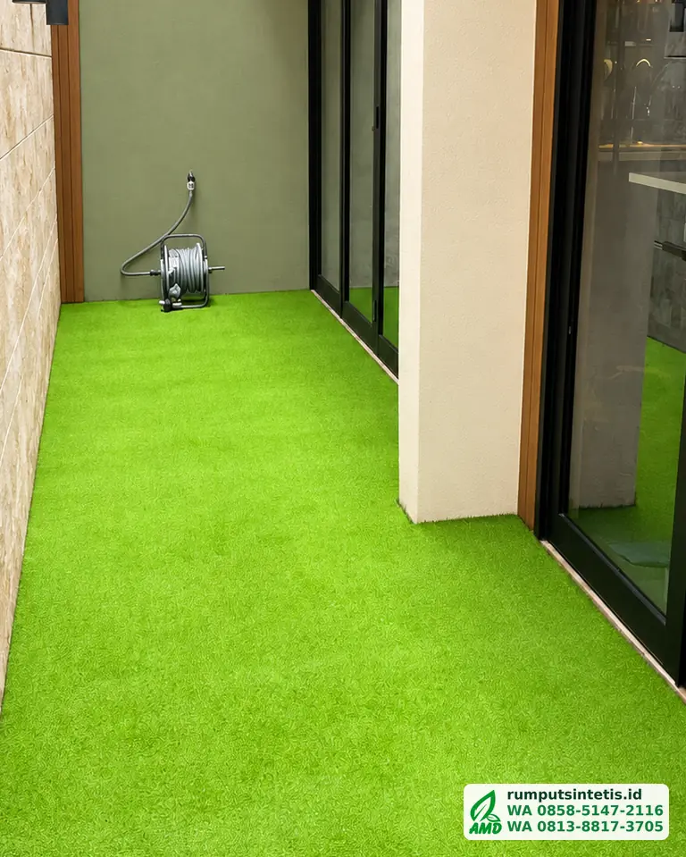 Lorong samping rumah dengan rumput sintetis