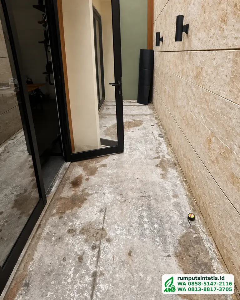 Lorong samping rumah berlantai semen sebelum dipasang rumput sintetis
