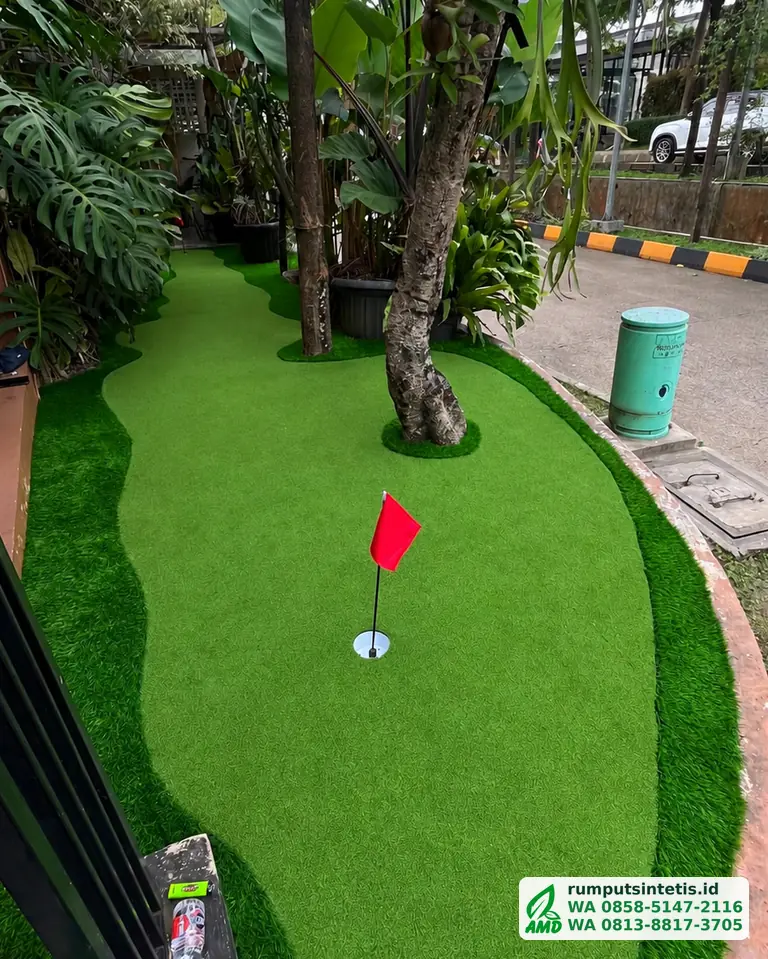 Putting green rumput sintetis di taman depan rumah dengan bendera golf