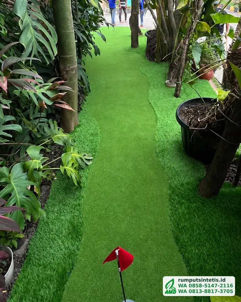 Taman depan rumah hijau dengan rumput sintetis dan putting green