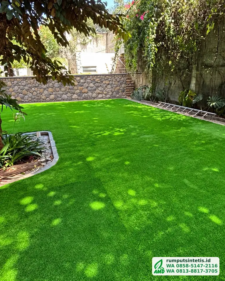 Taman rumput sintetis hijau di bawah pepohonan