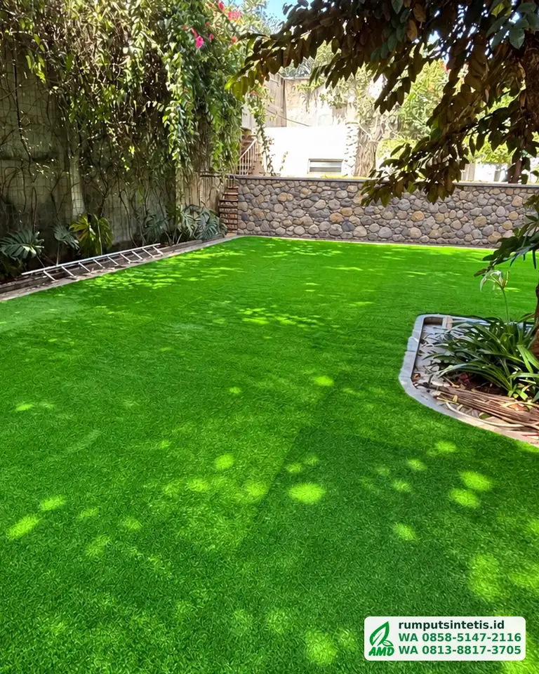 Taman rumput sintetis hijau di bawah pepohonan