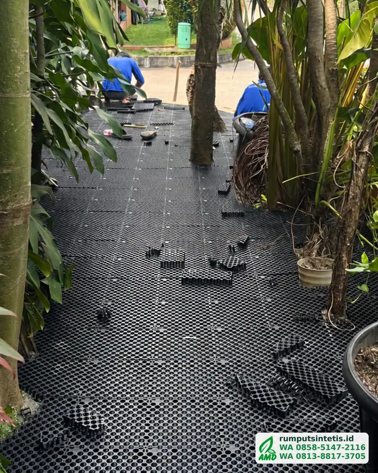 Tim memasang panel drainage cell di taman sebelum rumput sintetis digelar