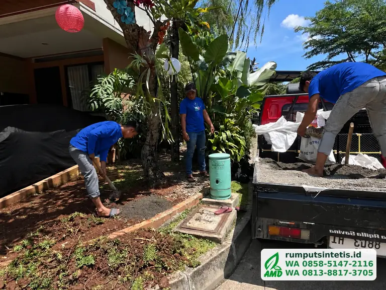 Tim membongkar tanah taman depan sebelum dipasang rumput sintetis